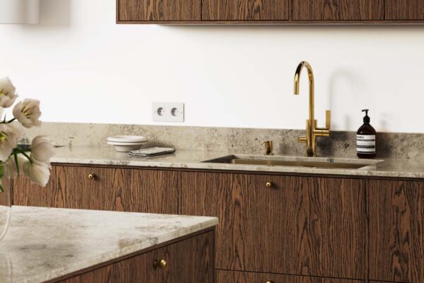 Bänkskiva Kalksten Jura Grey i kök med snickerier i dark oak och mässingsdetaljer
